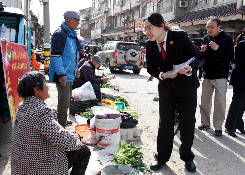 ①干警在“法律早市”向菜農(nóng)發(fā)放普法宣傳折頁.jpg